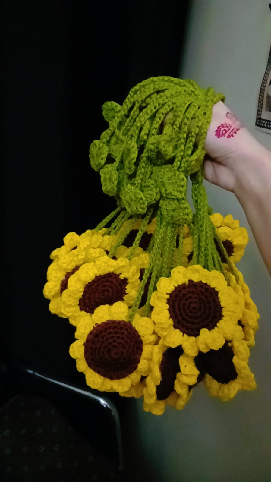 Handmade sunflower bouquet made of yarn held by a person.